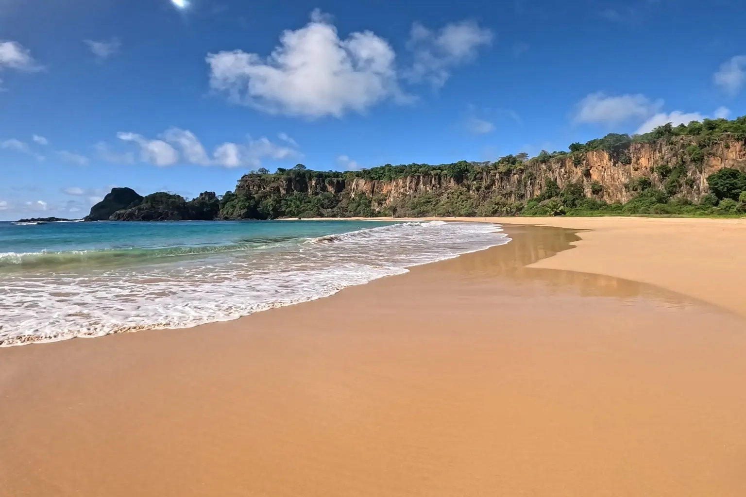 Praia do Sancho, em Fernando de Noronha, com areia dourada, falésias e mar azul